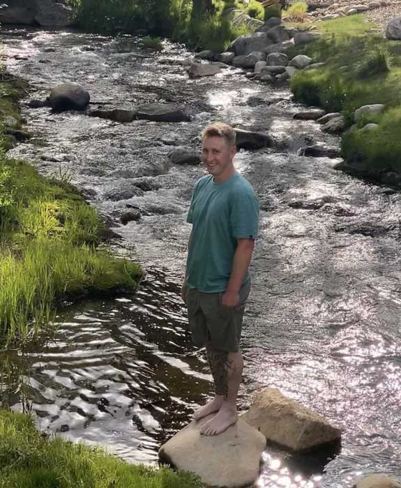 Parker Seemann standing on a rock by a river